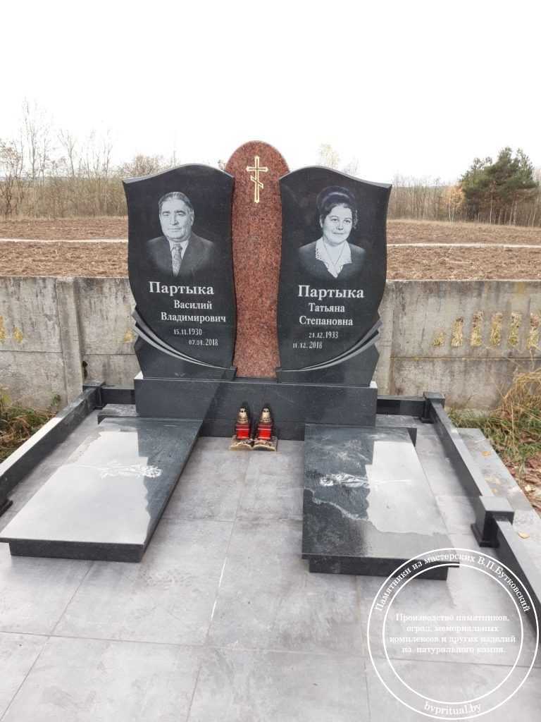 Два черных гранитных памятника с гравировкой портретов, объединенные в одну композицию с помощью декоративной вставки из красного гранита; фундамент покрыт черной гранитной плиткой, по периметру низкая оградка из черного гранита, в Гомеле | Бутковский